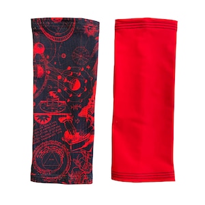 May include: Two arm warmers, one with a red and black geometric pattern and the other solid red.