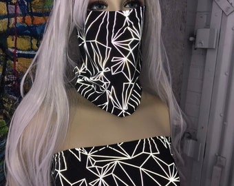 May include: A black and white geometric print tube top and face mask. The print is reflective and has a geometric pattern of white lines on a black background.