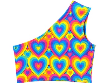 May include: A vibrant, one-shoulder crop top featuring a repeating pattern of layered hearts in a rainbow of colors. The design includes shades of pink, yellow, orange, blue, and purple. The top is likely made of a stretchy, form-fitting material.