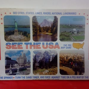 May include: A vintage board game titled "See the USA." The box features images of American landmarks and cities, including the Statue of Liberty and Yosemite National Park. The game is for 2 to 4 players and includes the text "The Peg Map Game."
