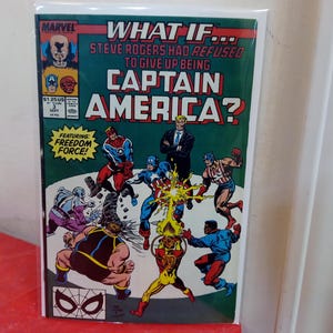 Puede incluir: Una portada de cómic titulada "What If... Steve Rogers Had Refused to Give Up Being Captain America?" presenta varios personajes en acción. El cómic de Marvel tiene un fondo verde con el texto "Featuring Freedom Force!"