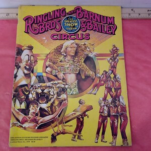 May include: A vintage Ringling Bros. and Barnum & Bailey Circus program cover featuring a yellow background with a colorful design. The cover features a tiger, a leopard, a clown, and a group of acrobats. The text on the cover reads "Ringling Bros. and Barnum & Bailey Circus".