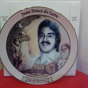 Puede incluir: Plato de coleccionista con un retrato de Juan Ponce de León, con el texto "Juan Ponce de León" y "Age of Discovery". El plato tiene un borde dorado e ilustraciones de figuras históricas.
