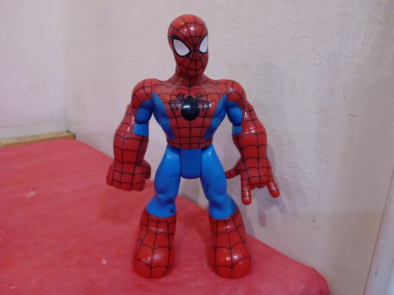 May include: A red and blue plastic action figure of Spider-Man. The figure has a black spider logo on the chest and a red and blue mask.