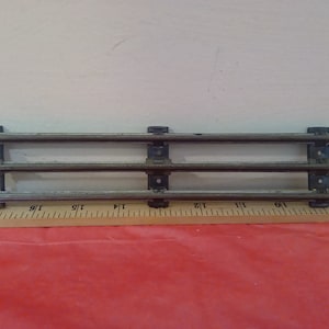May include: Three pieces of metal train track with three connecting pieces. The track is approximately 10 inches long.