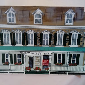 May include: A wooden model of a two-story building with a green roof and white trim. The building has a sign that reads "Oley Valley Inn" and a smaller sign that reads "The Clay Valley Wedding Inn". There is a red sign that reads "Open for Sunday Brunch".