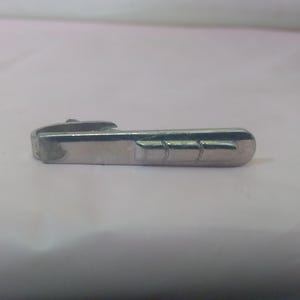 May include: A silver metal handle with a decorative groove design.