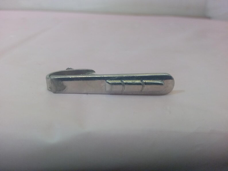 May include: A silver metal handle with a decorative groove design.