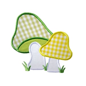 May include: Two embroidered mushrooms with gingham patterns. The larger mushroom is green and white, and the smaller mushroom is yellow and white. Both mushrooms have white stems.