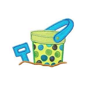 May include: A green and blue plastic bucket with a blue handle and a matching blue shovel. The bucket has a polka dot pattern with green, blue, and brown circles.