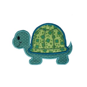 Op de afbeelding: Een geborduurde applicatie van een schildpad met een gepatenteerde schelp, in tinten blauw en groen.
