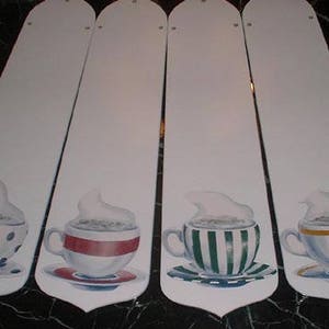 May include: Four white ceiling fan blades with painted designs of coffee mugs with steam rising from them. The mugs are decorated with polka dots, stripes, and a red band.