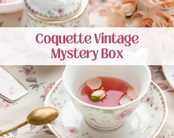 May include: A vintage teacup and saucer set with a floral pattern. The teacup is filled with pink liquid and a rosebud. The text "Coquette Vintage Mystery Box" is displayed on a white banner.
