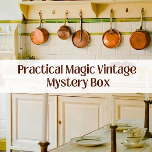 May include: A vintage kitchen setting with copper pans suspended above a white cabinet. The text "Practical Magic Vintage Mystery Box" is visible. A table is set with plates, cutlery, and candle holders.