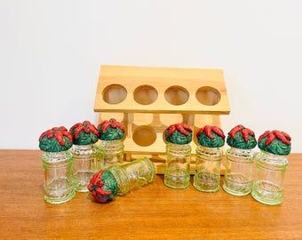 Estante de especias vintage de madera con frascos de vidrio verde, pimientos y mariquitas