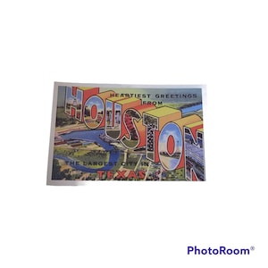 May include: A vintage postcard with a colorful illustration of the words "HEARTIEST GREETINGS FROM HOUSTON THE LARGEST CITY IN TEXAS". The postcard features an aerial view of the city with buildings, roads, and a river.