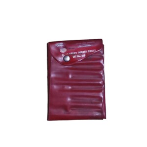May include: A red leather case with a metal snap closure. The case contains a set of drill bits labeled "H.S. GREEN JOBBER DRILLS SET No. 219".