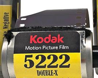 May include: Four clear plastic canisters and one metal film cartridge of Kodak 5222 Double-X black and white negative motion picture film. Each container features a yellow label with black text stating 5222 Double-X, 35 mm 36 Exp. ISO 250.