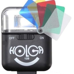 Pode incluir: Um flash preto com um logotipo branco "HOLGA 12S" e um rosto sorridente. O flash tem um interruptor com as etiquetas "OFF" e "ON". Existem quatro filtros coloridos presos ao flash: azul, amarelo, vermelho e verde.