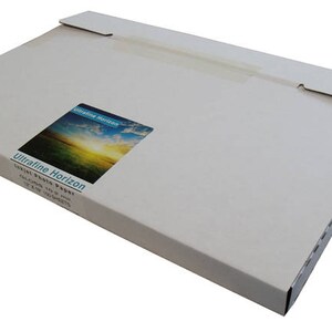May include: A rectangular, light-colored cardboard box with a flap closure. A sticker on the front displays a landscape image with the text "Ultrafine Horizon" and "Inkjet Photo Paper". The box is designed to hold paper.