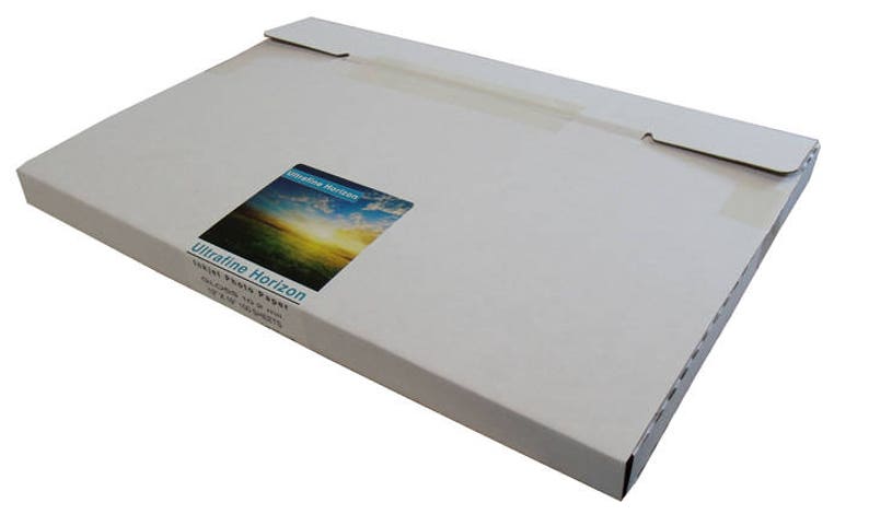 May include: A rectangular, light-colored cardboard box with a flap closure. A sticker on the front displays a landscape image with the text "Ultrafine Horizon" and "Inkjet Photo Paper". The box is designed to hold paper.