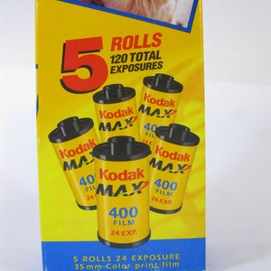 May include: A yellow Kodak film box with the text "5 Rolls 120 Total Exposures." The box contains five yellow film canisters labeled "Kodak MAX 400 Film 24 EXP." A picture of a child and a dog is at the top.