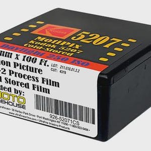 May include: A black rectangular film canister featuring a white label with the text 35 mm X 100 Ft. Motion Picture ECN-2 Process Film Cold Stored Film loaded by Photo Warehouse, including a barcode and the Kodak 5207 Daylight 250 ISO branding.