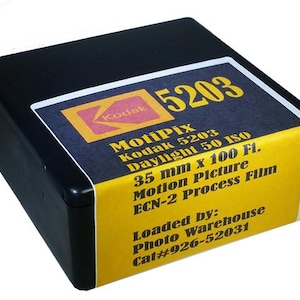 May include: A black box of Kodak 5203 MotiPix 35mm motion picture film, daylight 50 ISO, 100 feet. The box is labeled with the text "Loaded by: Photo Warehouse Cat#926-52031".
