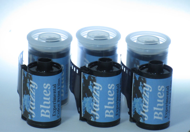 May include: Three rolls of 35mm color print film with blue and white labels. The labels read "Jazzy Blues Experimental Color Print Film".
