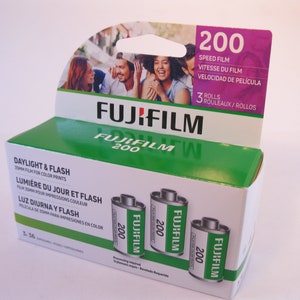 May include: A box of three rolls of Fujifilm 200 speed film for daylight and flash photography. The box is green and white with a picture of people on the front. The film is 35mm and is for color prints.