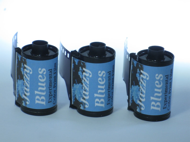 May include: Three rolls of 35mm film with blue and white labels that read "Jazzy Blues Experimental Color Print Film".