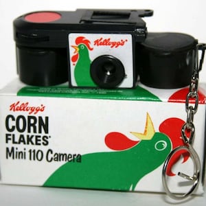 Llavero con cámara de película en miniatura de 110 pulgadas con copos de maíz de Kellogg&#39;s y tubo de envío original
