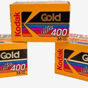 May include: Three boxes of Kodak Gold Ultra 400 film. Each box is yellow with black and blue stripes and the text "Kodak Gold Ultra 400" in red and white.