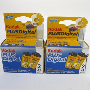 May include: Two packs of Kodak Plus Digital 400 film, each containing two 24-exposure rolls. The packaging is yellow and blue with the text "Kodak Plus Digital" and "Kodak Picture CD" included when you buy prints.