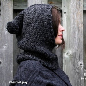 May include: Charcoal gray knit hooded scarf with a pom pom on the top. Lambs wool blend. Knit Hood by Winter White Knits.