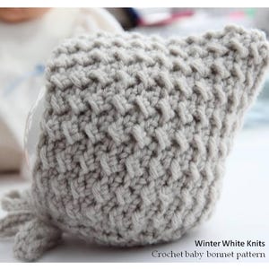 May include: A light grey, textured crochet baby bonnet with ties. The bonnet is made with a basketweave stitch and is part of the "Winter White Knits" collection. The text "Crochet baby bonnet pattern" is visible.