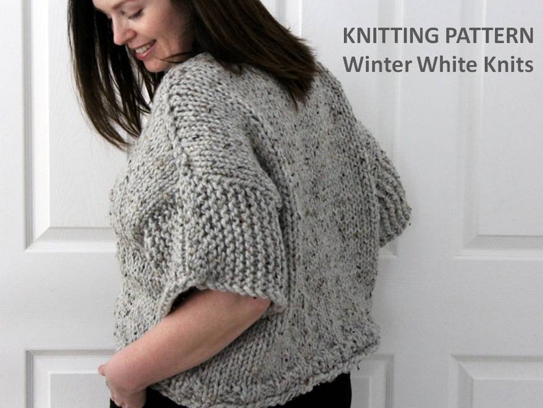 May include: A gray knitted sweater with a speckled texture. The sweater has a loose fit and short sleeves. The text "KNITTING PATTERN Winter White Knits" is visible at the top of the image.