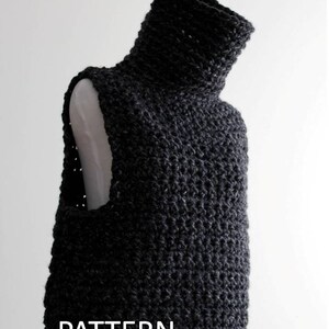 Puede incluir: Un chaleco de punto de ganchillo negro con cuello alto. El chaleco est&aacute; hecho con un punto texturizado y es sin mangas. El texto "PATTERN By Winter White Knits" est&aacute; impreso debajo del chaleco.