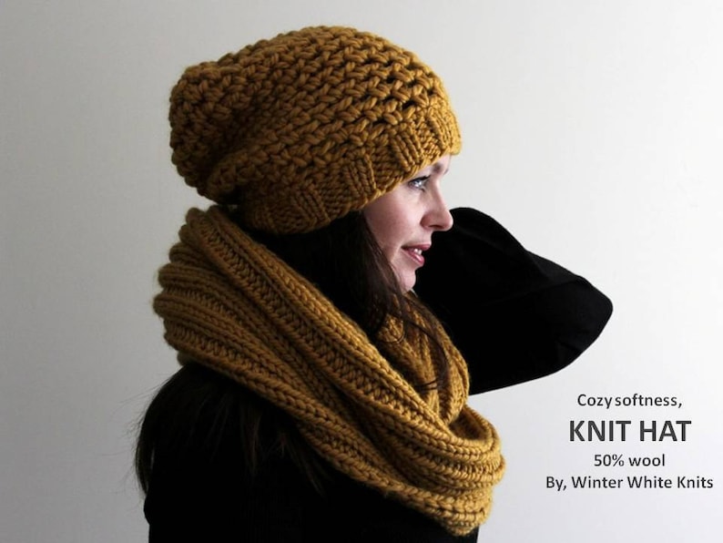May include: A cozy, mustard yellow knit hat and matching infinity scarf. The hat is slouchy and the scarf is thick and warm. The text "Cozy softness, KNIT HAT 50% wool By, Winter White Knits" is visible in the image.