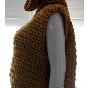 Puede incluir: Un top sin mangas de crochet marr&oacute;n con un cuello alto de cuello alto. El top est&aacute; hecho con un patr&oacute;n de punto simple y tiene un ajuste holgado.