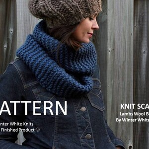 May include: A chunky blue knit infinity scarf worn with a brown knit beanie and a dark denim jacket. The image includes the text: PATTERN, KNIT SCARF, Lambs Wool Blend, By Winter White Knits, Not a Finished Product.