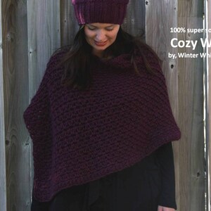 May include: A woman wearing a burgundy crocheted wrap made of 100% super soft wool. The wrap is called "Cozy Wrap" by Winter White Knits.
