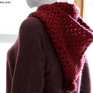 May include: A close-up of a maroon crocheted cowl with a textured pattern. The cowl is worn over a maroon sweater.