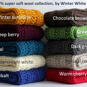May include: A stack of ten 100% super soft wool knit scarves in various colors, including winter sunshine, chocolate brown, green, deep berry, teal, polar cream white, cobalt, dark grey, natural cool, and warm cherry red. 100% super soft wool collection, by Winter White Knits.