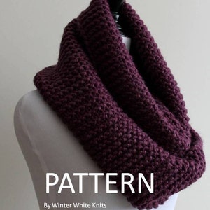 May include: A deep purple chunky knit infinity scarf draped on a mannequin. The text reads: Lambs Wool Blend By, Winter White Knits, PATTERN By Winter White Knits Not a Finished Product.