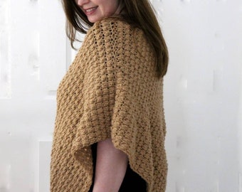 May include: A tan crocheted poncho with a textured stitch pattern.