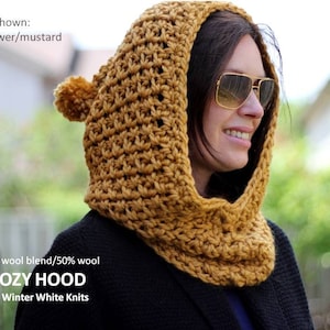 May include: A mustard yellow crocheted cowl with a pom pom on the top. The cowl is made of a soft wool blend and is called "Cozy Hood" by Winter White Knits.