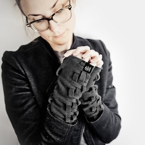 May include: Gray fleece fingerless gloves with a braided design and a small black label with the text "Knitwit" on the wrist.