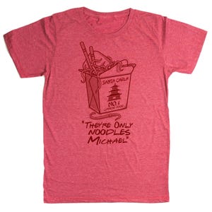 May include: Red t-shirt with a graphic of a Chinese food takeout box, chopsticks, and noodles. The text on the box reads "Santa Carla No. 1 Chinese Food." Below the box, the text says "They're Only Noodles Michael."