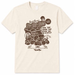 Op de afbeelding: Een crèmekleurig T-shirt met korte mouwen en een bruine grafische print van aardappelen met de tekst "Samwise Gamgee's Po-Tay-Toes", "Boil 'em! Mash 'em! Stick 'em in a stew!" en "Pairs perfectly with a nice piece of fried fish."